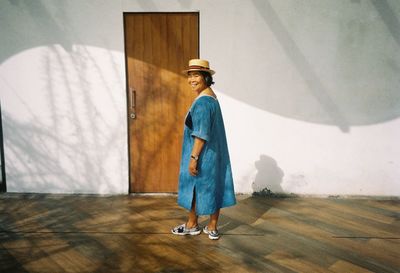 Rear view of woman standing against wall