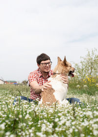 Summer leisure time, pet care and training. happy man plays with mixed breed shepherd dog