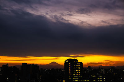 Silhouette buildings against sky during sunset