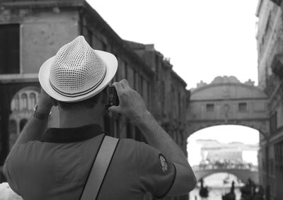 Rear view of man photographing bridge of sighs
