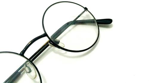 High angle view of eyeglasses on table against white background