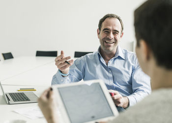 Smiling businessman and businesswoman in conference room