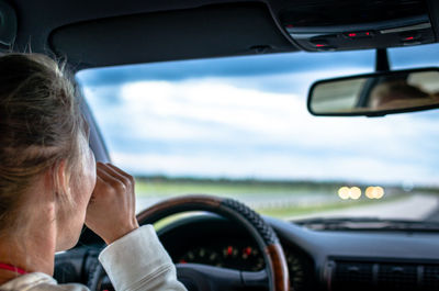 Rear view of woman sitting in car