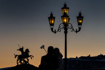 Silhouette couple taking selfie from smart phone at sunset