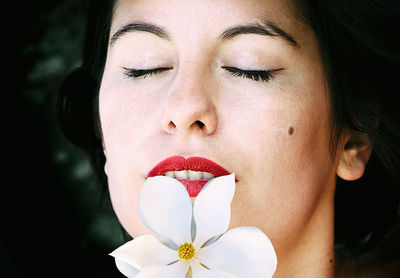 Woman with closed eyes and a magnolia tree on her lips