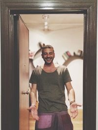 Happy man standing on doorway