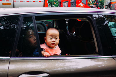 Portrait of boy looking through car window