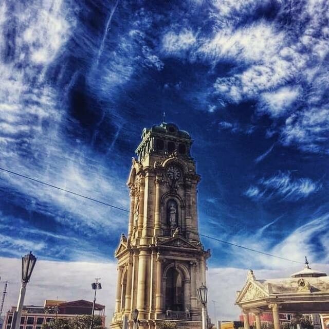 architecture, building exterior, built structure, low angle view, sky, religion, church, place of worship, cloud - sky, spirituality, cloud, cloudy, cathedral, blue, tower, cross, day, history