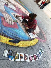 High angle view of woman with multi colored painting on wall