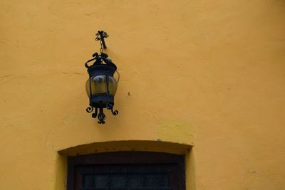 Low angle view of yellow wall with lamp