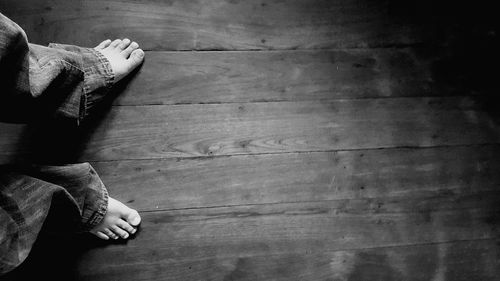 Low section of person standing on hardwood floor