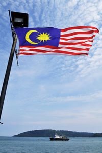 Flag of malaysia flying against sky 