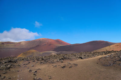 Scenic view of desert against blue sky