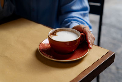 Woman holding beautiful cup with fresh coffee. perfect day beginning