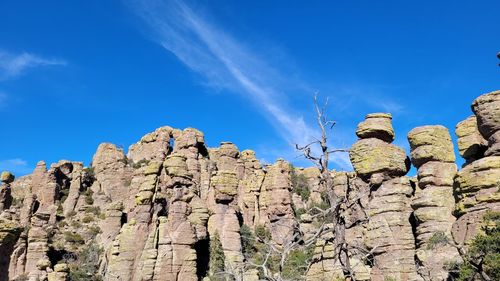 Low angle view of rocks against blue sky