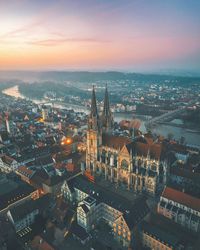 High angle view of city at river during sunset