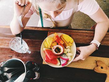 High angle view of woman having fruits at restaurant