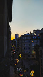 City street and buildings against sky at dusk