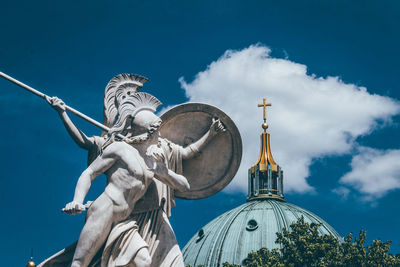 Low angle view of statue and church against sky