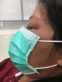 Close-up of sick woman wearing surgical mask