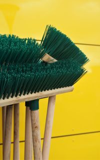 Close-up of brooms against wall