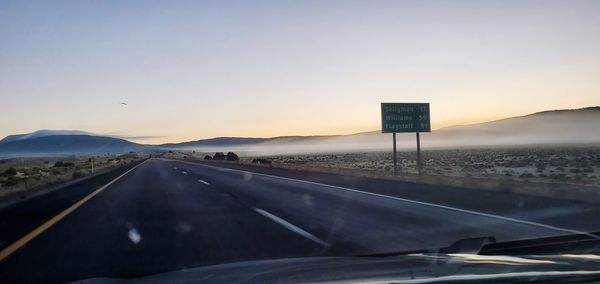 Road against clear sky seen through car windshield