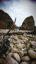 Stack of stones on rock against sky