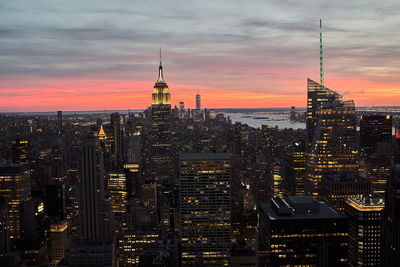 Illuminated buildings against sky during sunset