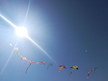 Low angle view of kites flying against clear sky