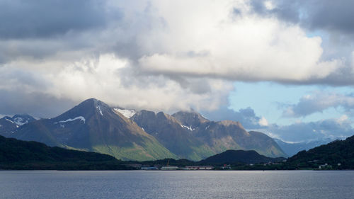 Scenic view of lake by mountains against sky