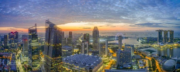 Aerial view of buildings in city at sunset