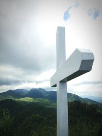 Cross on mountain against sky