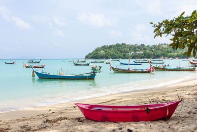 Boat moored on beach against sky
