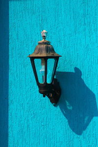 Close-up of lamp against blue wall