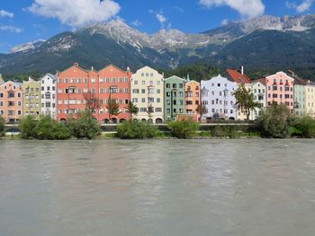 Residential buildings by mountains against sky