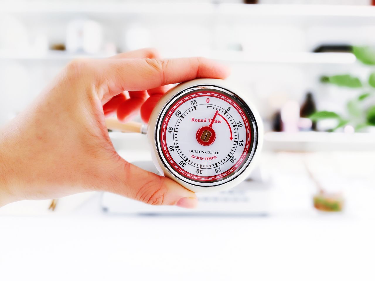 CLOSE-UP OF PERSON HOLDING CLOCK