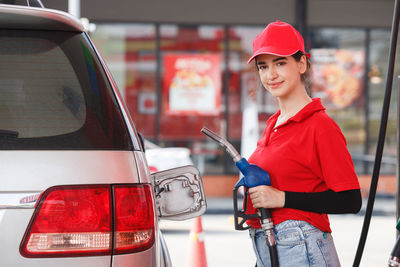 Portrait of smiling woman working at gas station