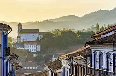 View of old colonial style city of ouro preto with houses, churches and hills at sunset