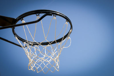 Low angle view of basketball hoop against clear blue sky