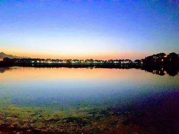 Scenic view of lake against clear sky at sunset