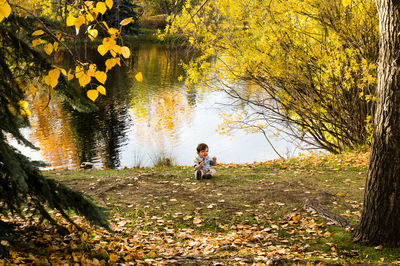 Little boy sitting on lakeshore