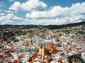 Aerial view of townscape against cloudy sky