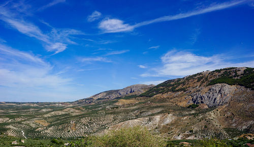 Scenic view of mountains against blue sky