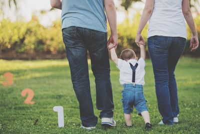 Low section of family walking on field