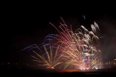 Low angle view of firework display at night