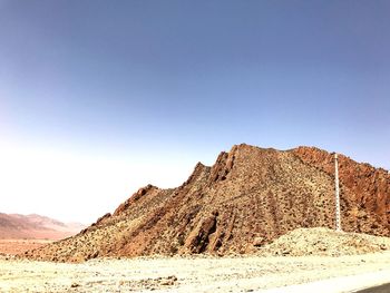 Scenic view of desert against clear blue sky