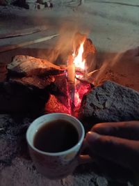 Cropped hand of person burning tea