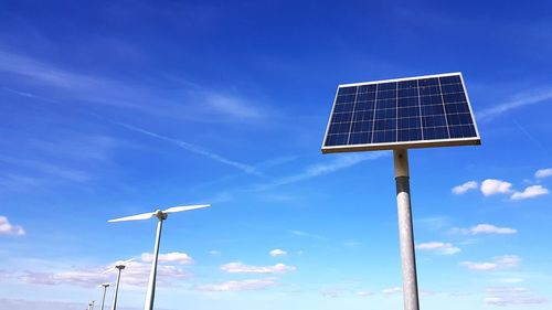 Low angle view of wind turbine against blue sky