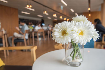 White flower vase on table in restaurant