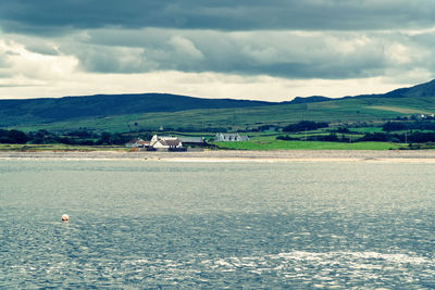 Scenic view of sea and mountains against sky